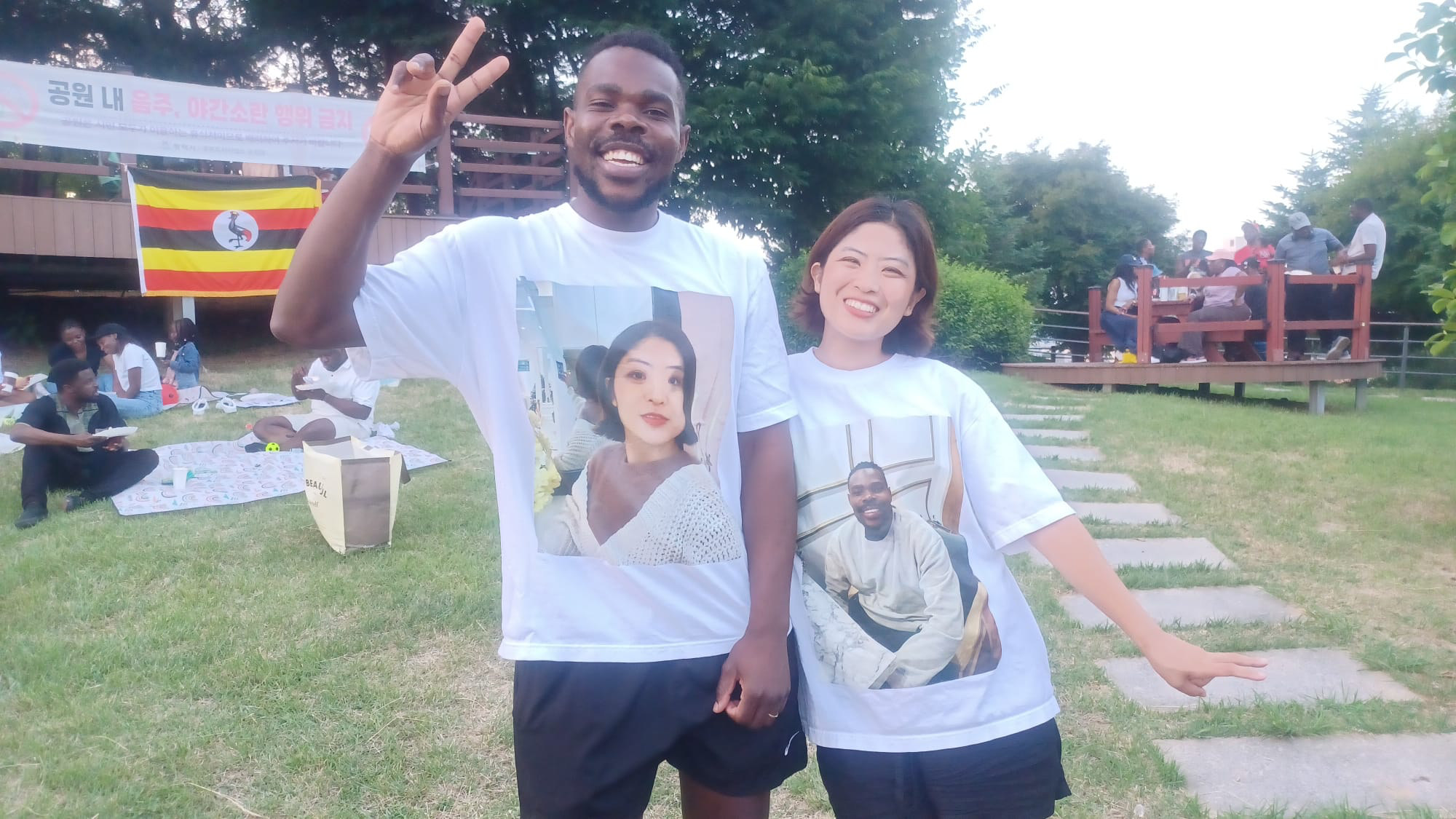 Members posing with custom shirts and the Uganda flag at Songtan