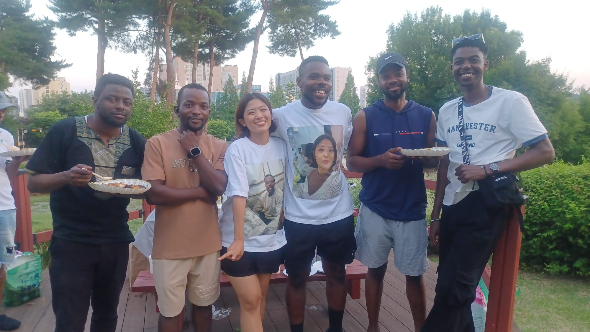 Group of friends with plates of food at the Songtan community picnic