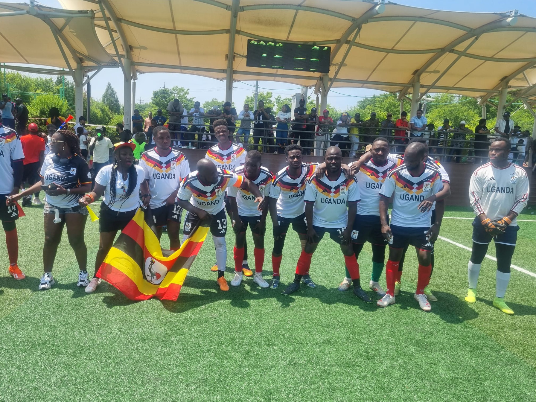 Team Uganda line-up with Uganda flag after a KAFCON match