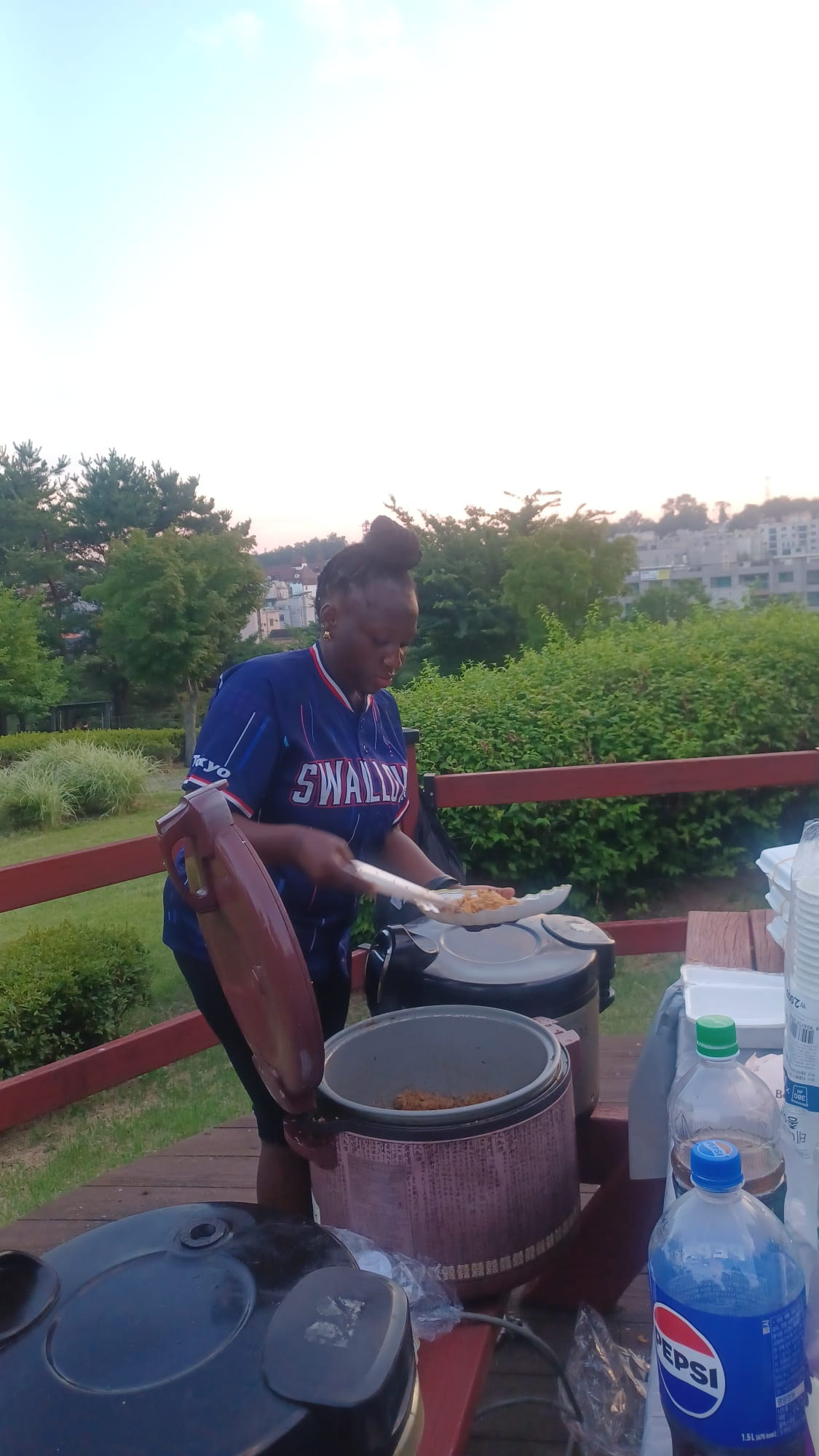 Community member serving Ugandan food at Sinjang Neighborhood Park